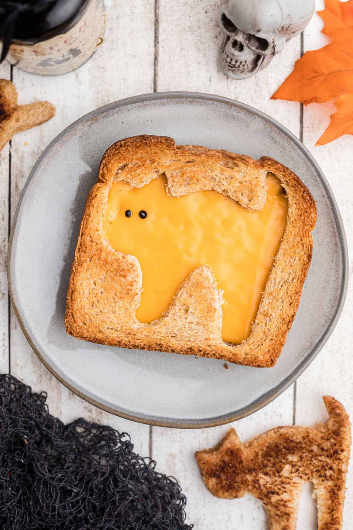 Overhead shot of a grilled cheese sandwich with a halloween cat cut out.