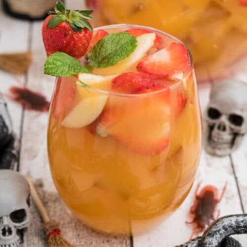 close up of a glass of jungle juice with a skeleton in the background.