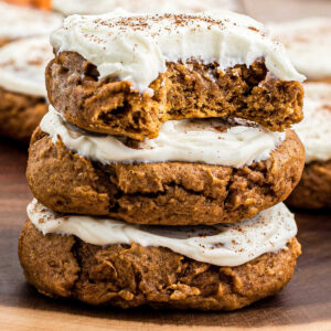 A stack of pumpkin cookies with cream cheese frosting.