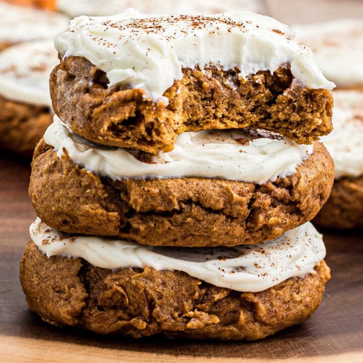 A stack of pumpkin cookies with cream cheese frosting.