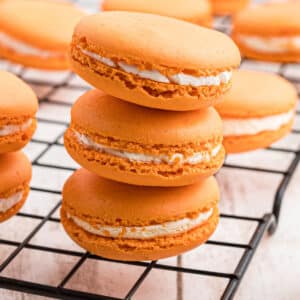 A close up shot of a stack of three pumpkin spice macarons.