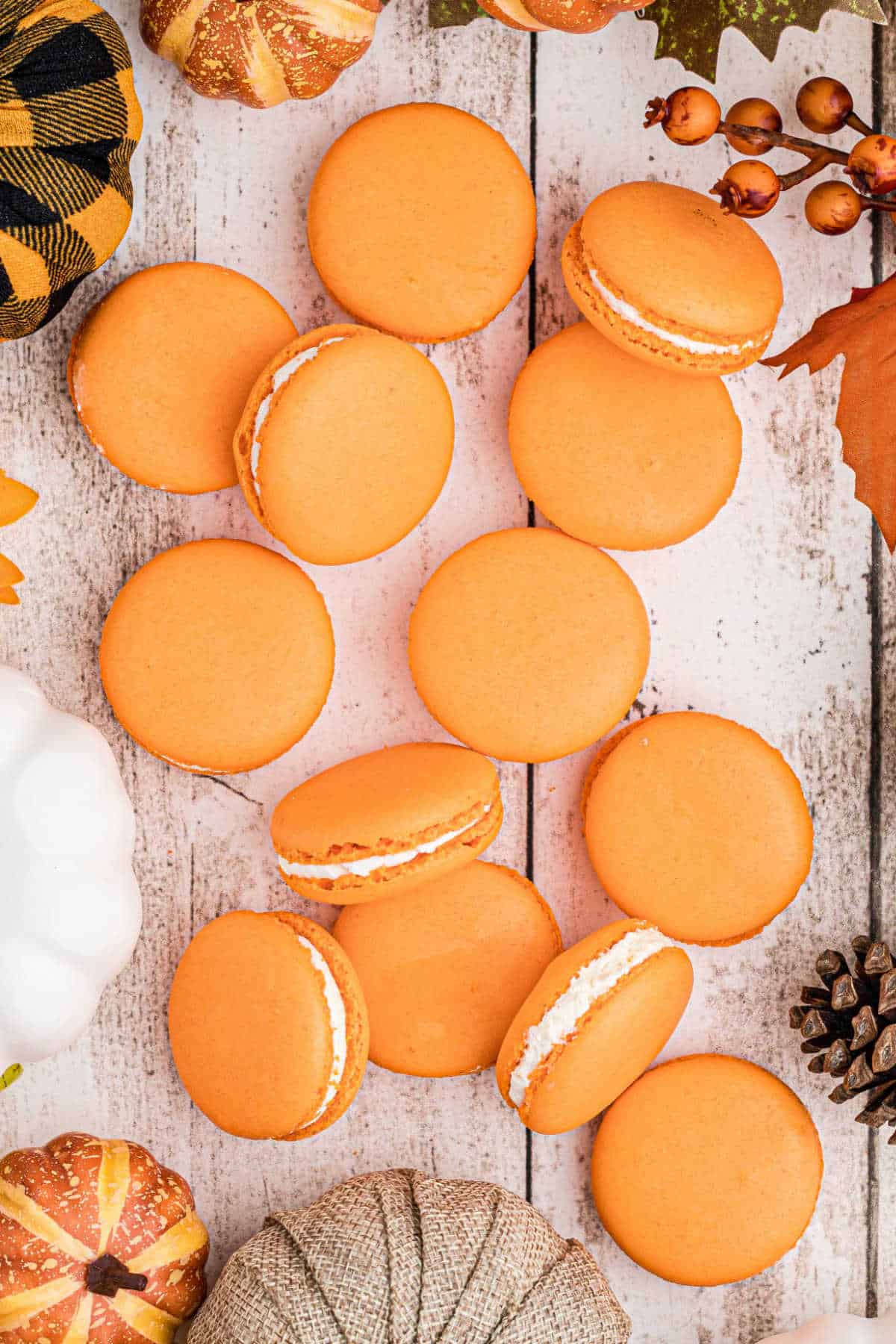 An overhead shot of pumpkin spice macarons laid out on a table.