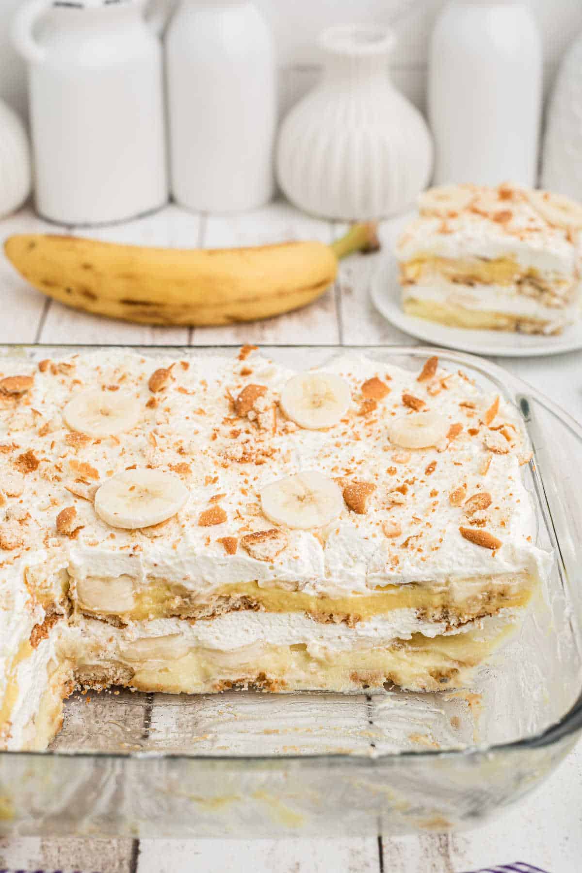 View from the side of a dish with banana pudding in it with a few pieces taken out.