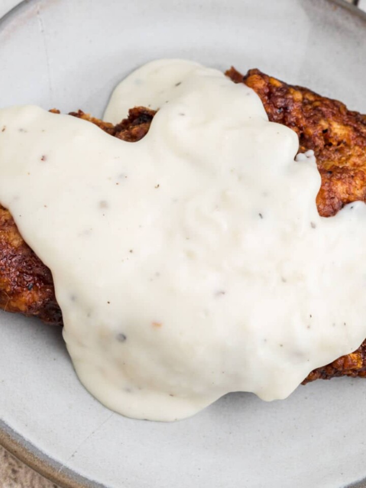 Overhead shot of southern white gravy poured over a pork chop.