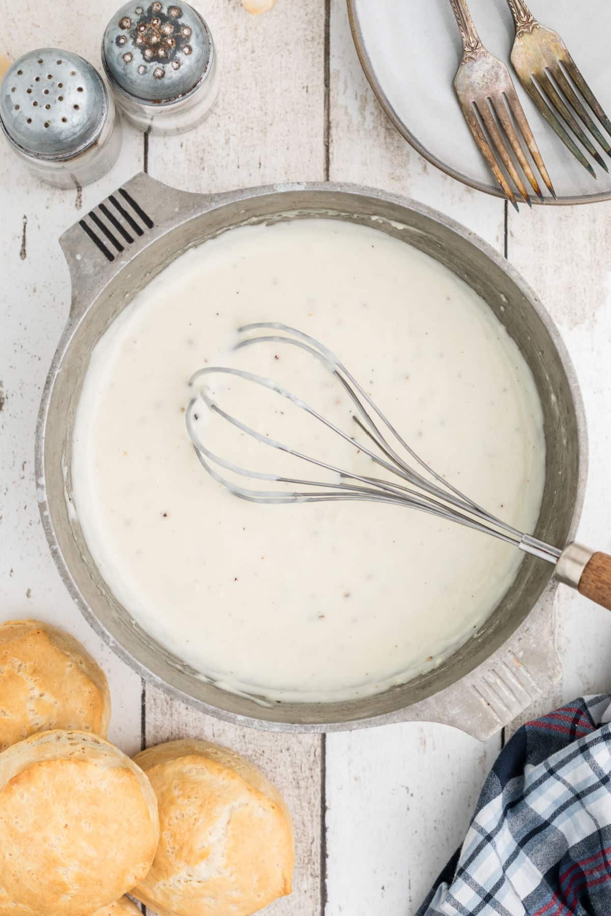 Southern white gravy in a pot with a whisk.