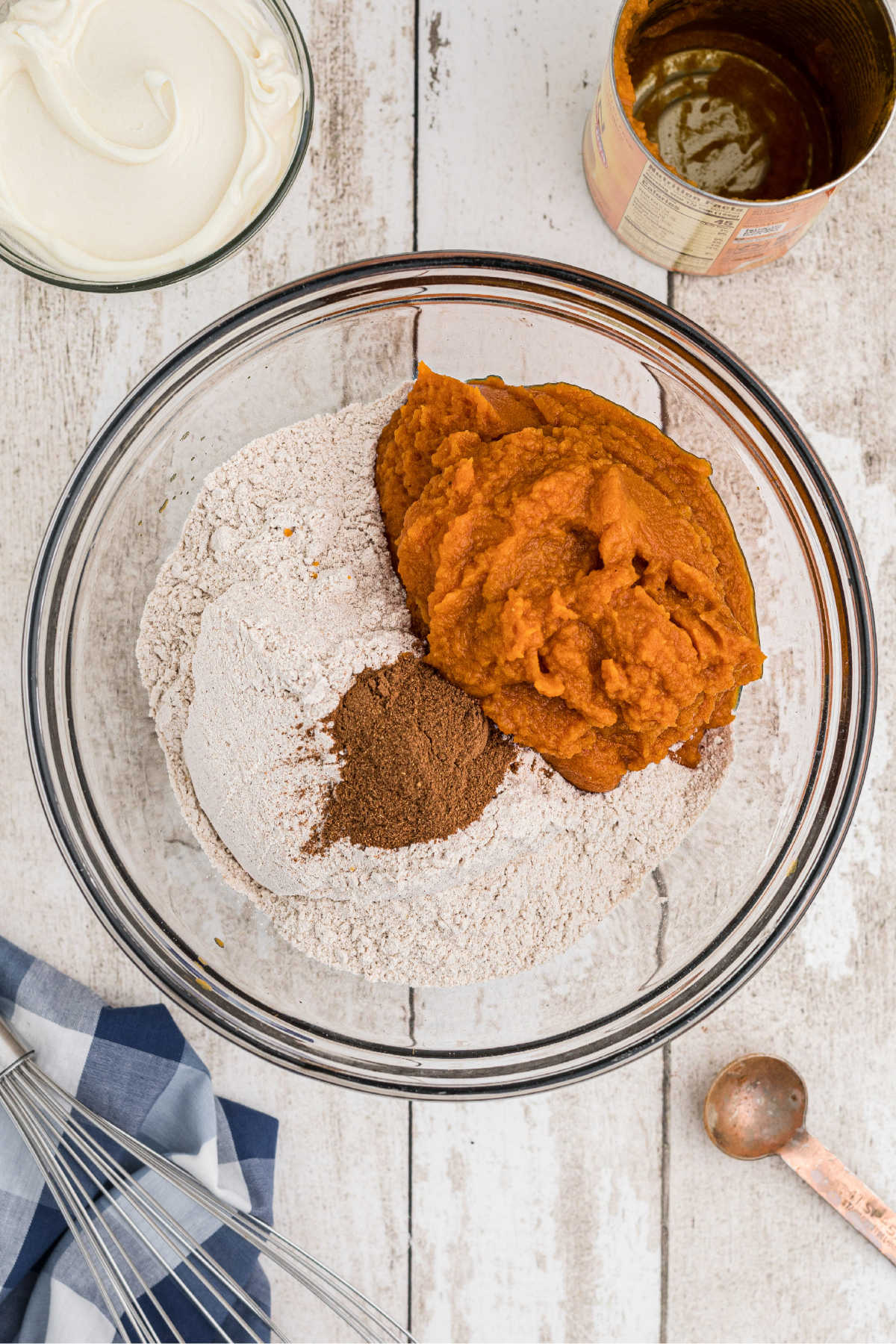 A large mixing bowl with cake mix, pumpkin and spices.