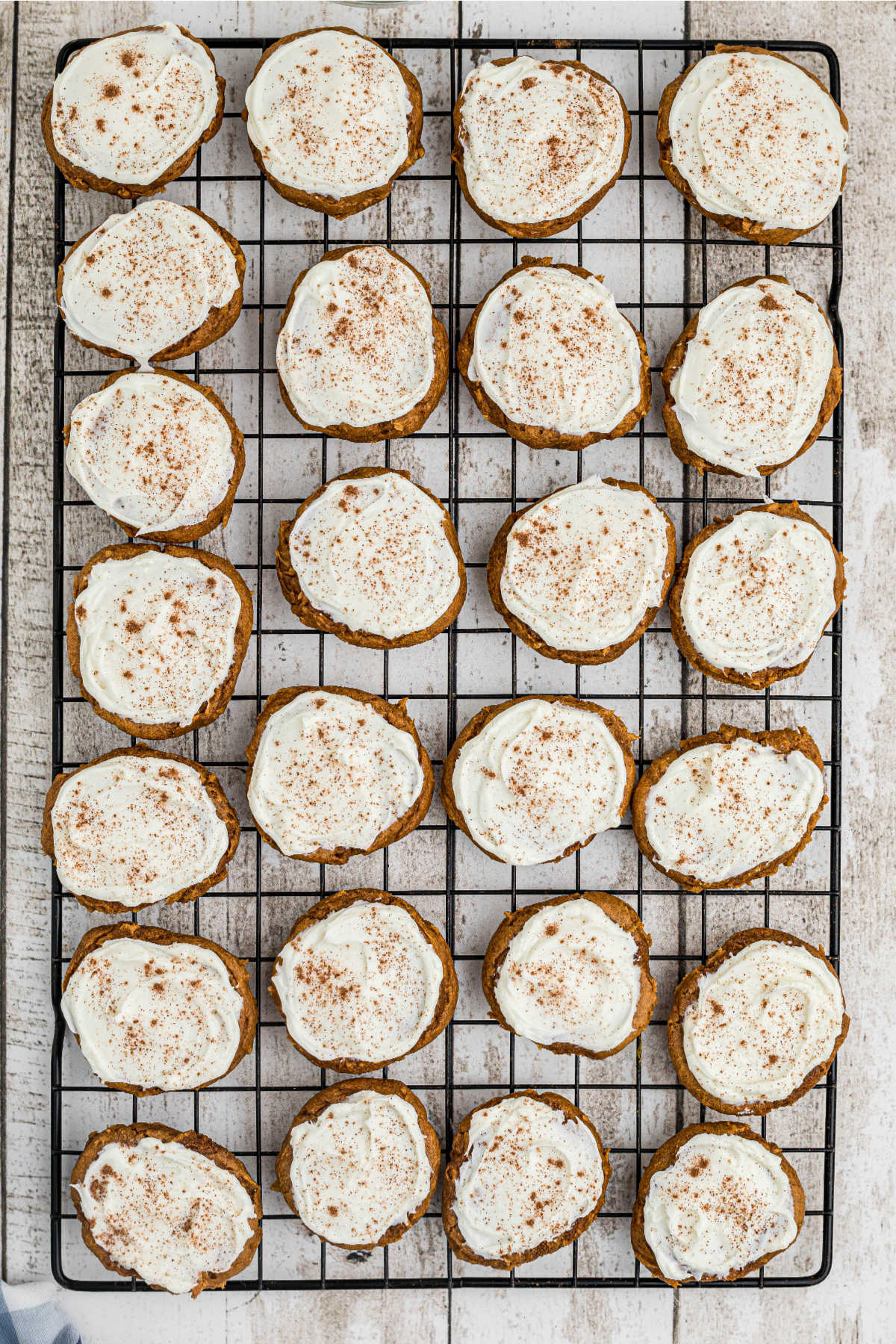 Pumpkin spice cookies lined up on a wire rack to cool... then frosting applied.