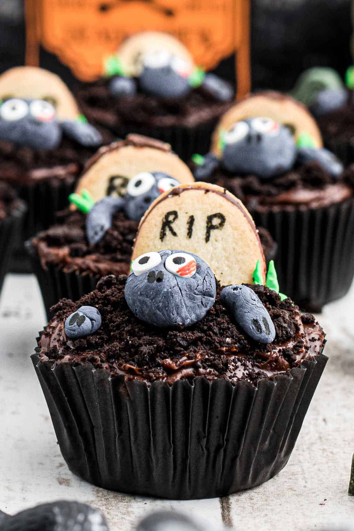 Close up of a zombie cupcake with more zombie cupcakes behind.