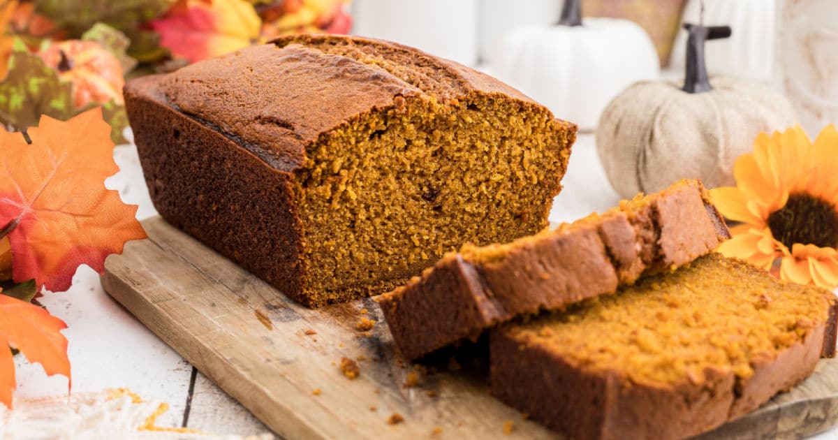 A close up of a loaf of pumpkin bread with a few slices cut out.