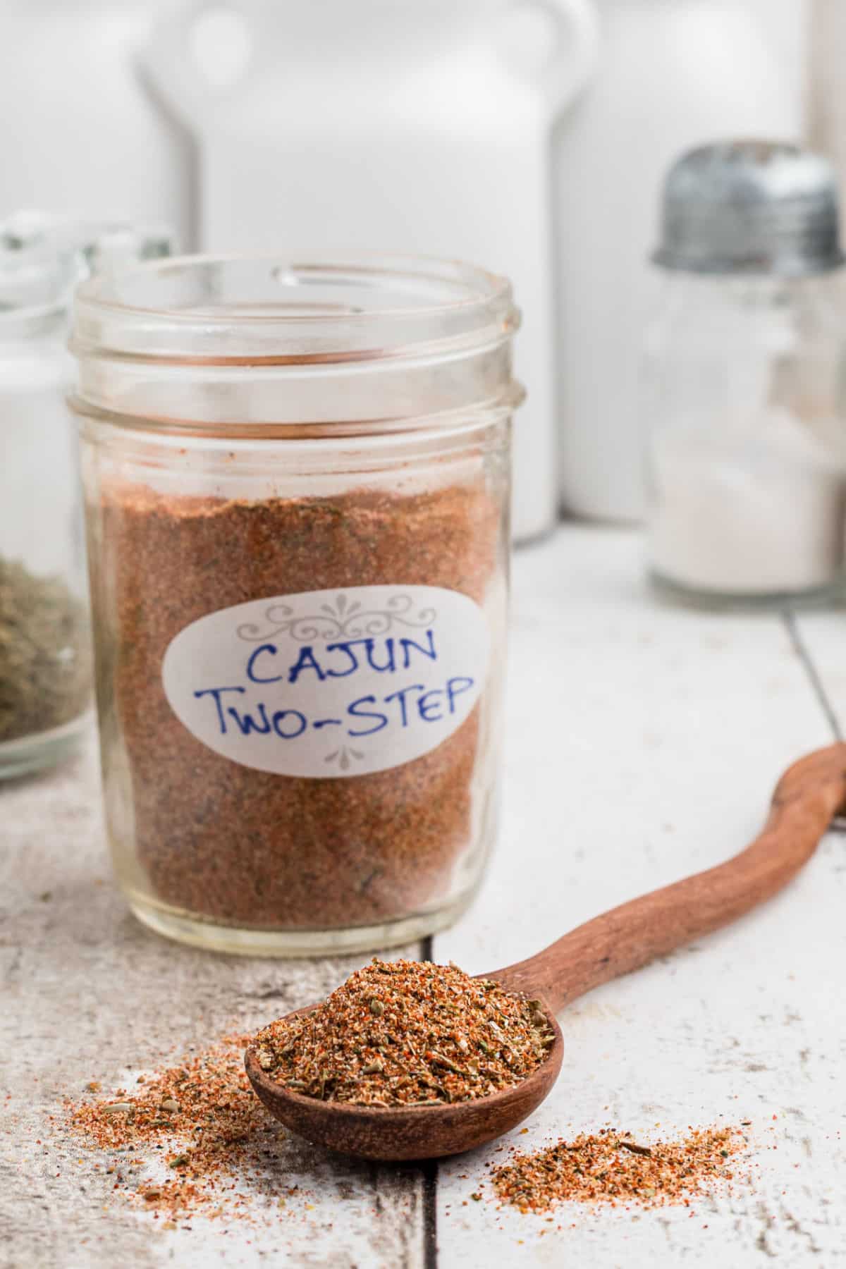 A jar of Cajun two step seasoning with a spoon in front.