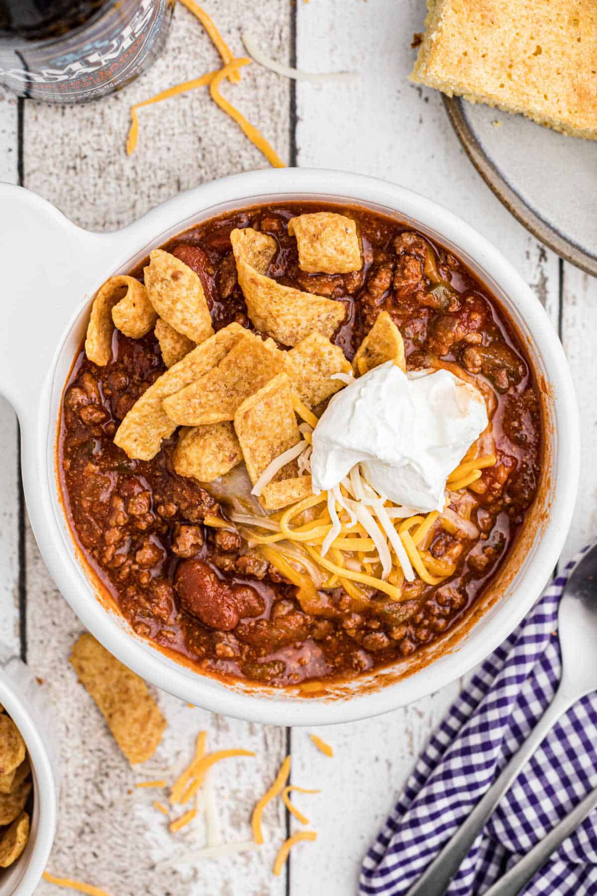 Overhead close up of a bowl of crock pot chili with fritos and sour cream.