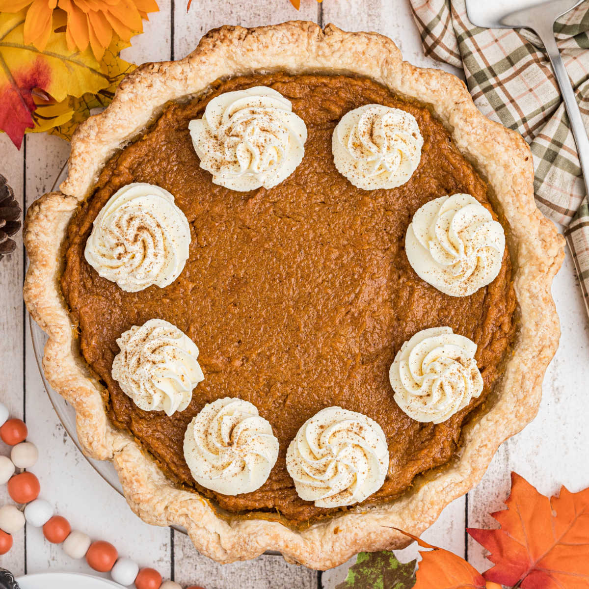 Overhead shot of a sweet potato pie with swirls of cream.