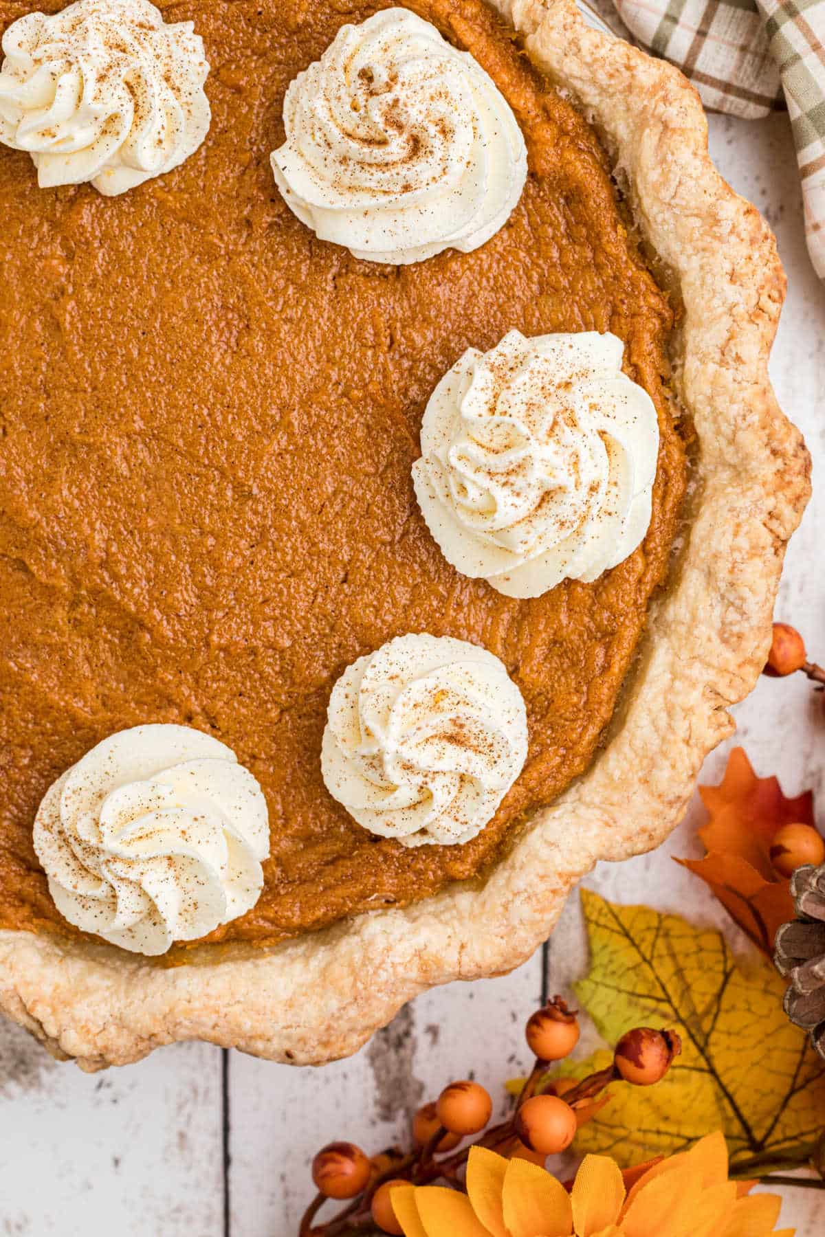 Close up shot of an old fashioned sweet potato pie with swirls of cream.