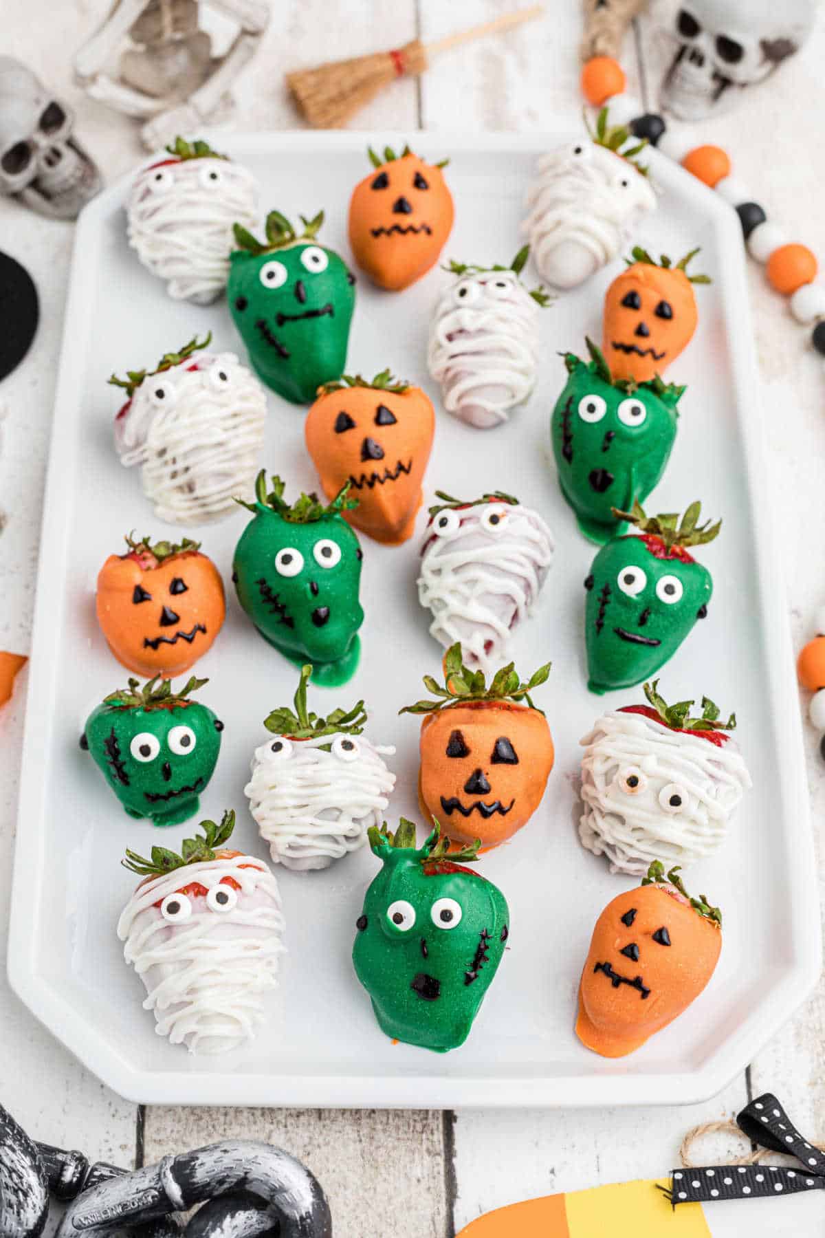 A plate of halloween themed chocolate covered strawberries.
