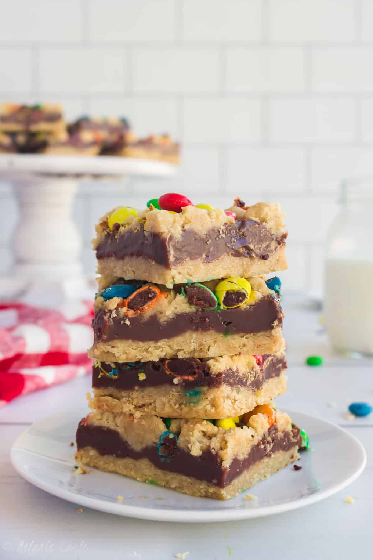 M&M Chocolate Oat bars stacked in four, on a plate.