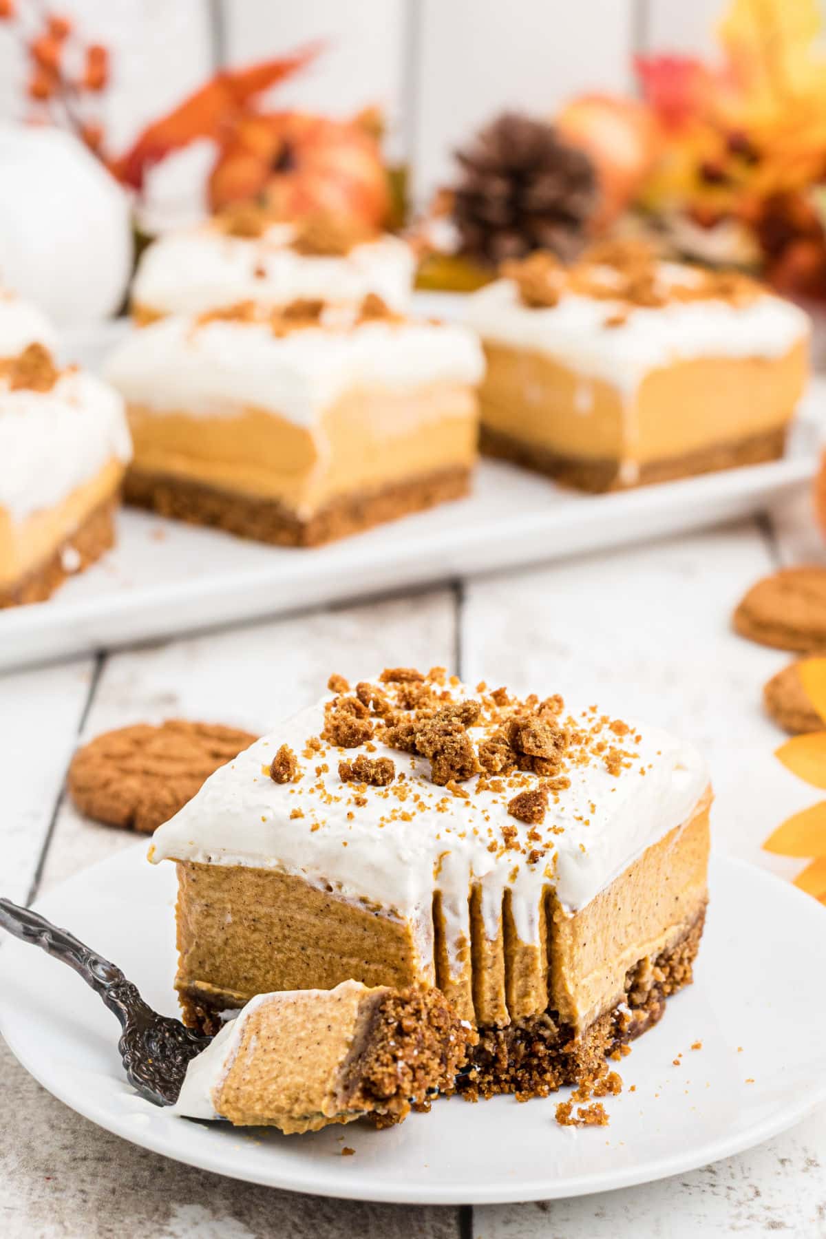 Slice of pumpkin cheesecake bars with a fork imprint in the front.