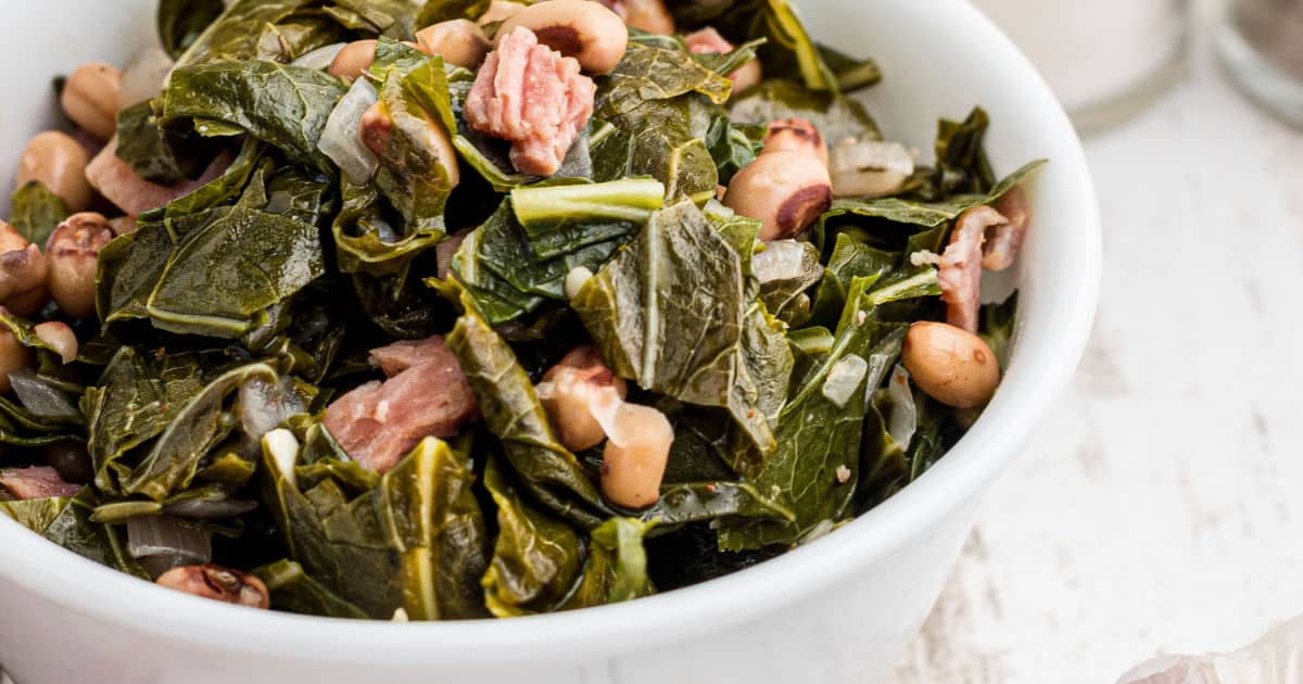 A close up of some black eyed peas and collard greens.