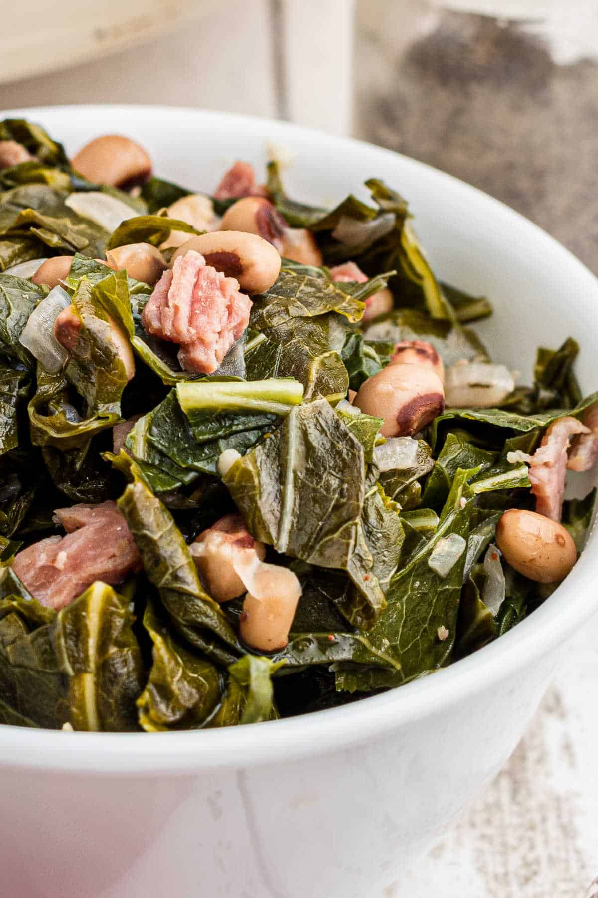 Close up of a bowl of collard greens with black eyed peas.