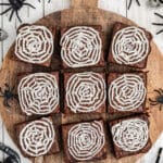 A wooden board with spider web brownies with text overlay for pinterest.