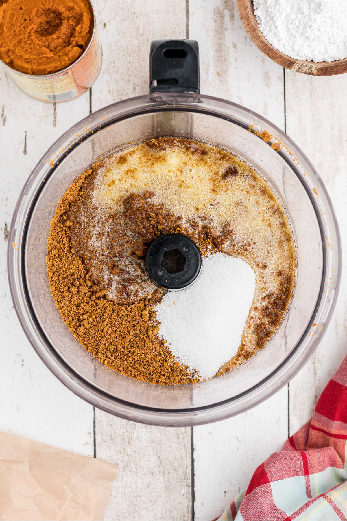 A food processor with cookie crumbs and sugar. 