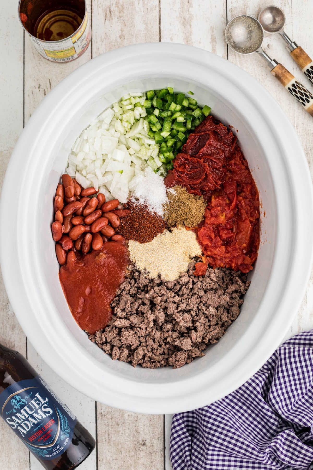 Ingredients for a crock pot beer chili recipe all loaded into the slow cooker.