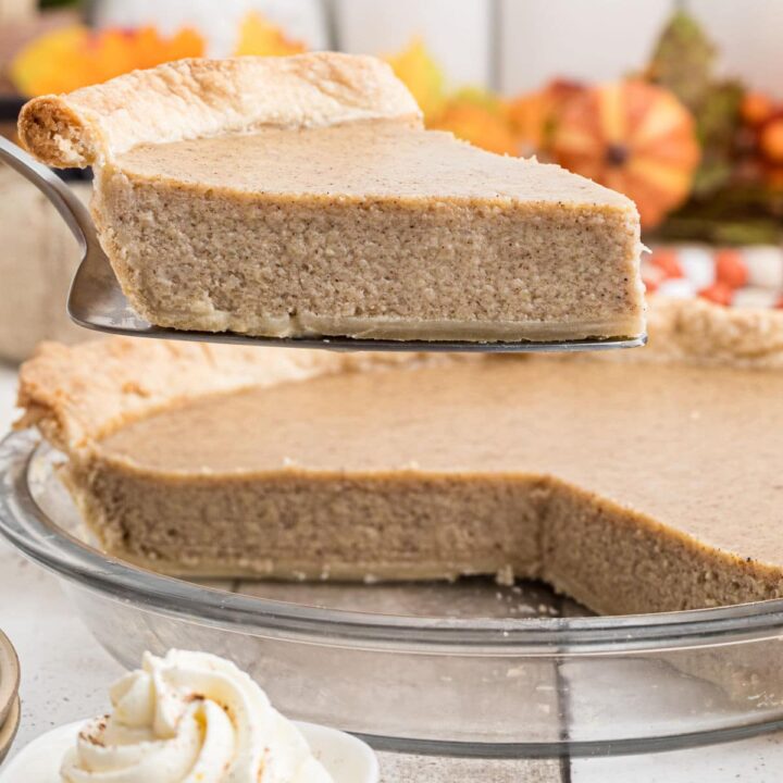Close up of a slice of white pumpkin pie being taken out of a pie dish.