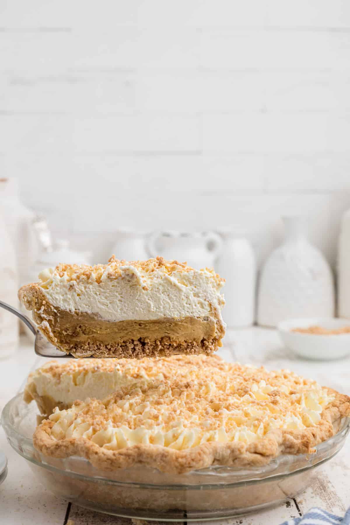 A slice of Amish peanut butter pie being lifted out of the pie dish.