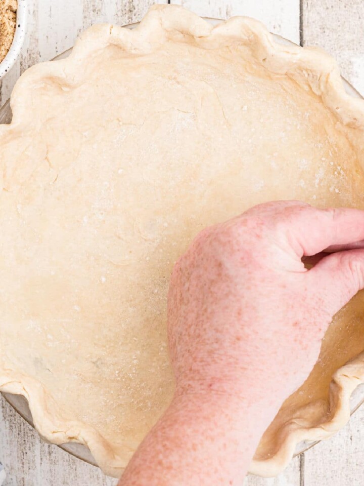 Hands fluting the edges of an Amish Pie Crust.