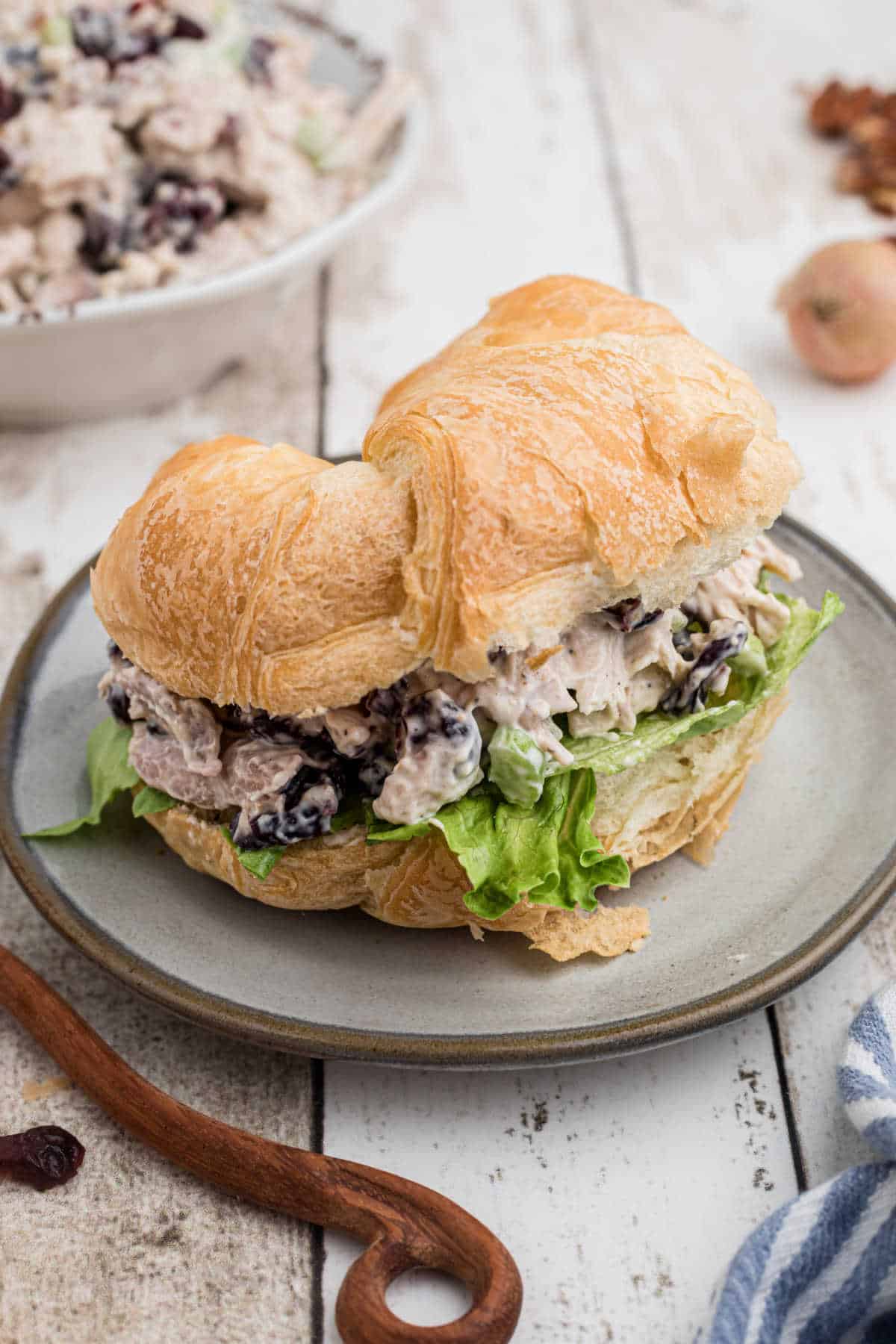 A croissant filled with cranberry pecan chicken salad and lettuce.