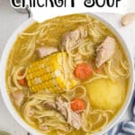 Overhead shot of a bowl of cuban chicken soup with the title above as text overlay for Pinterest.