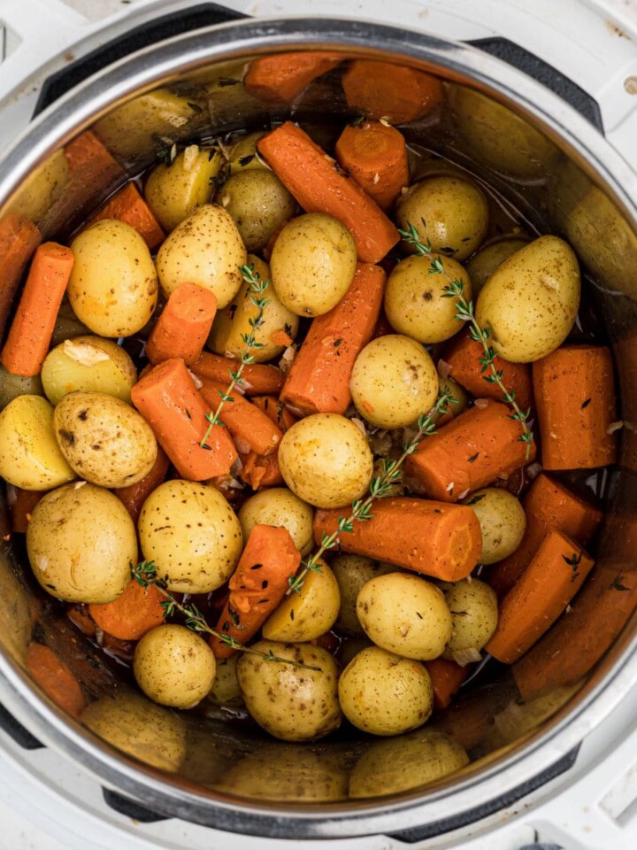 Close up overhead of an instant pot with potatoes and carrots.