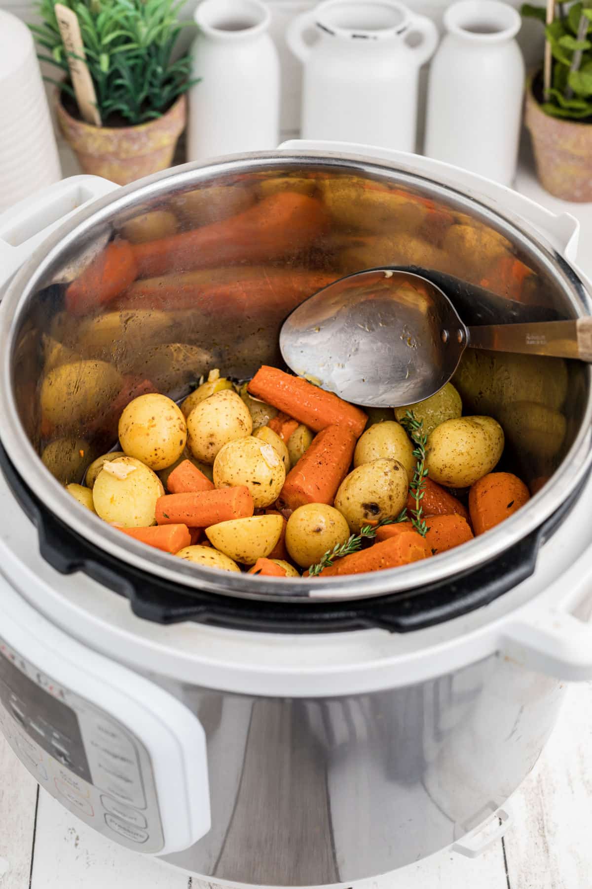 An instant pot potatoes and carrots recipe with a spoon digging in.