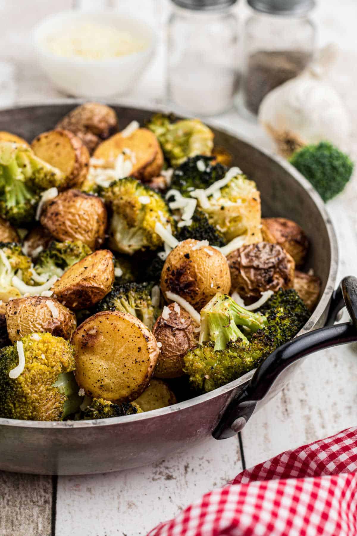 Side shot of a pan of roasted potatoes and broccoli.