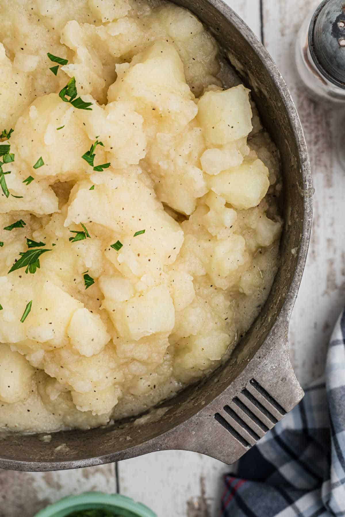 Overhead close up side shot of a pot of stewed potatoes.