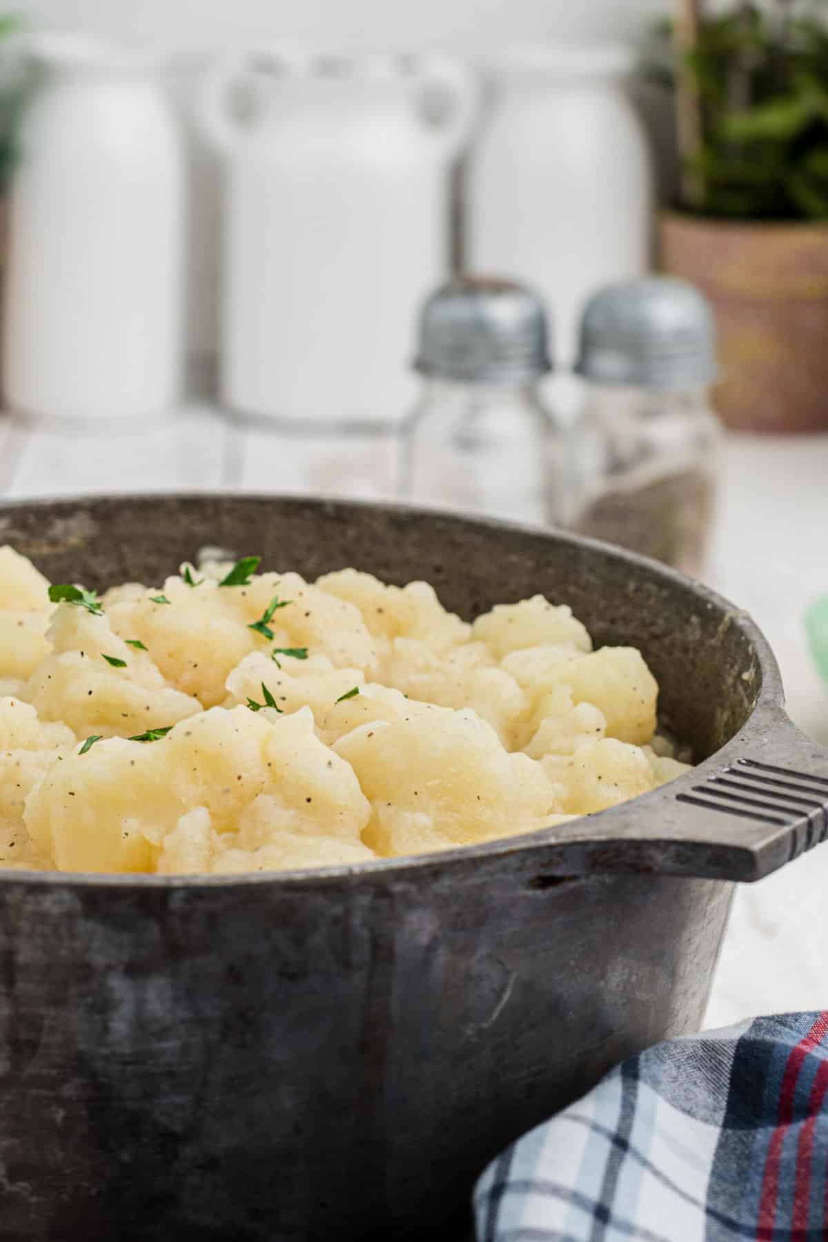 Side shot of the side of a pot of stewed potatoes.