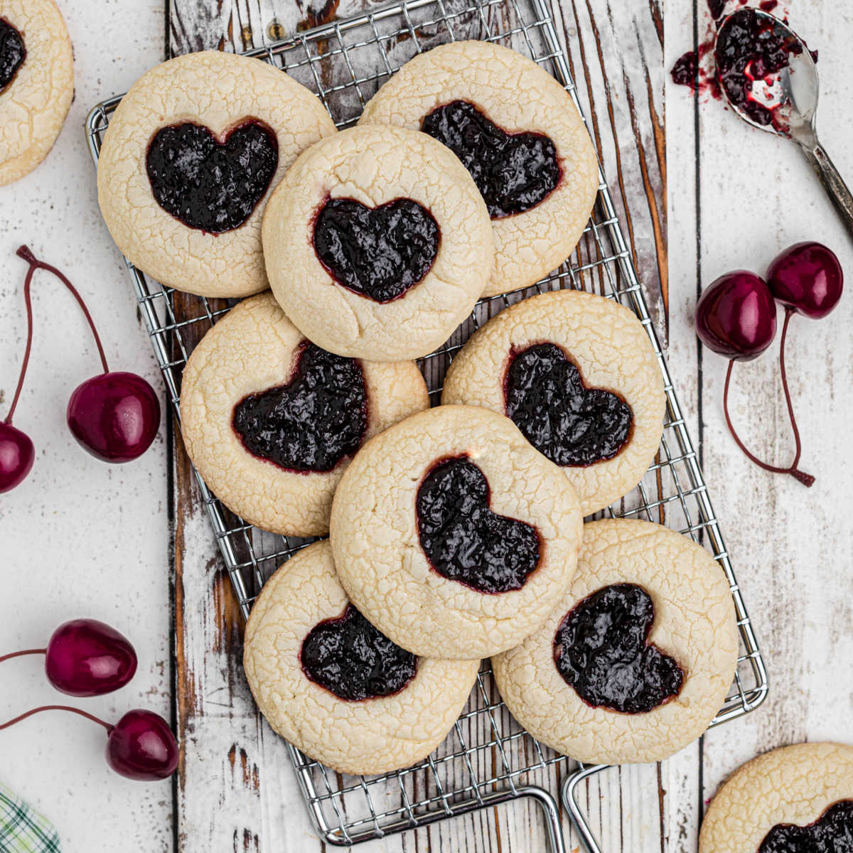 A wire rack over a piece of white wood with a pile of tiktok jam heart cookies.