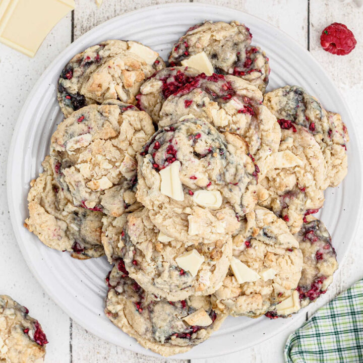 An overhead shot of a plate full of white chocolate raspberry cookies.