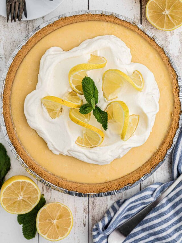 Overhead shot of a southern lemon pie recipe with some cream and lemon slices in the middle and a sprig of mint.