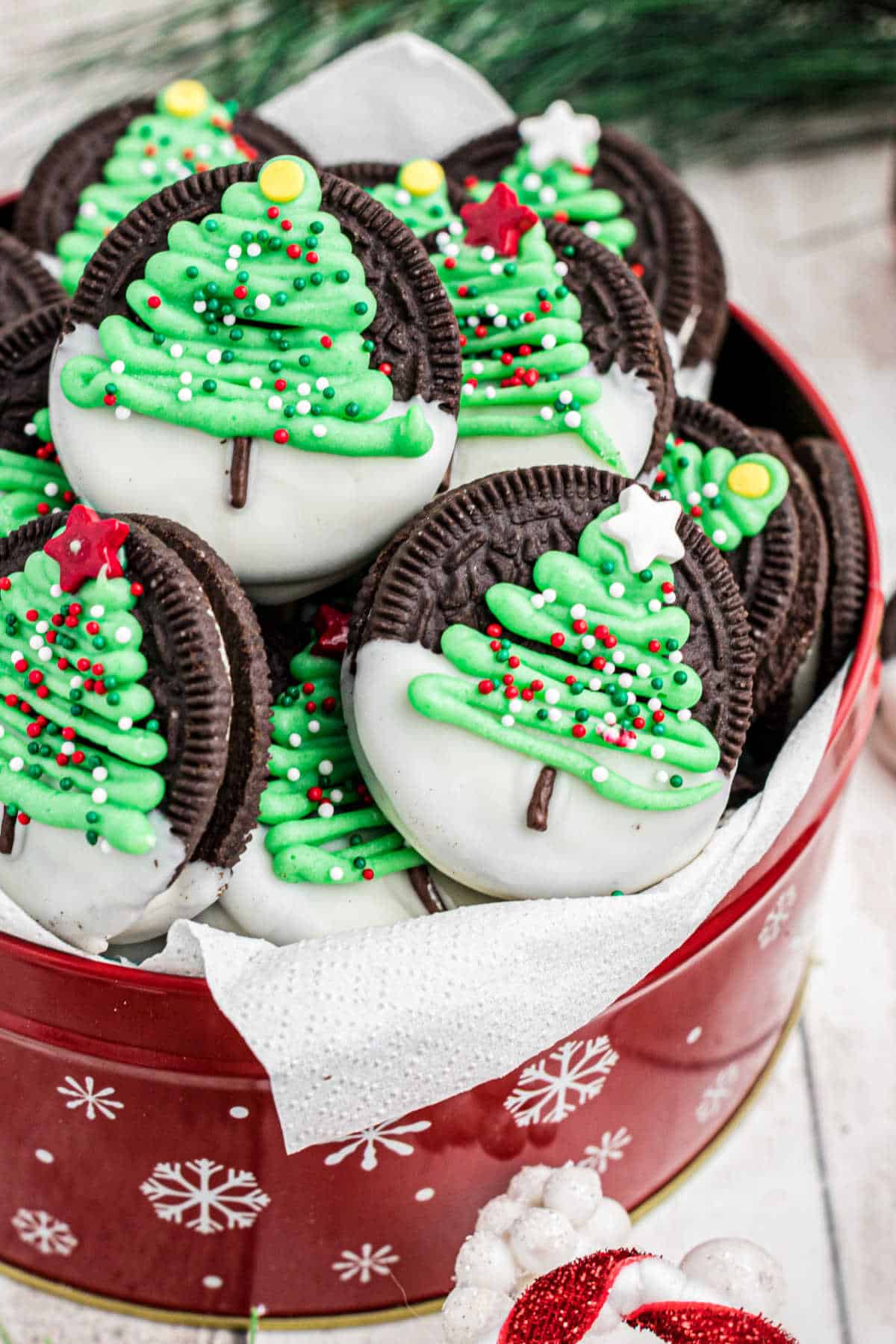 Side view of a tin of Christmas oreo cookies with a christmas tree.