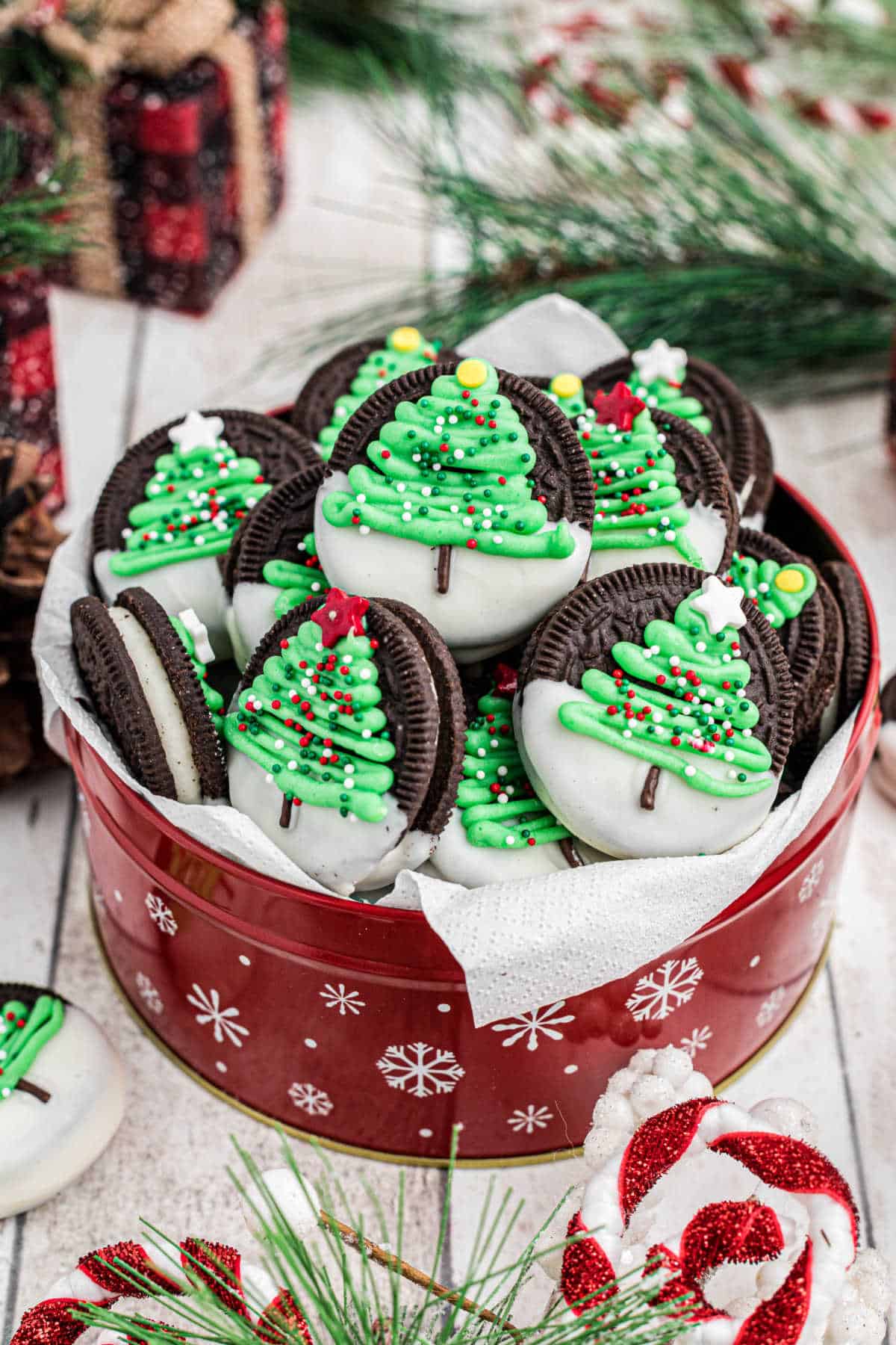 Beautifully arranged tin of christmas oreo cookies with christmas trees.