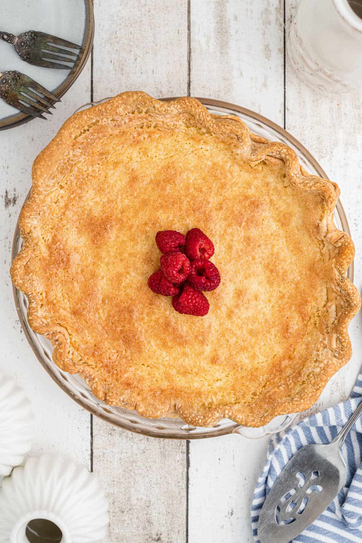 Overhead shot of a Cracker Barrel Buttermilk Pie Recipe with raspberries in the middle.