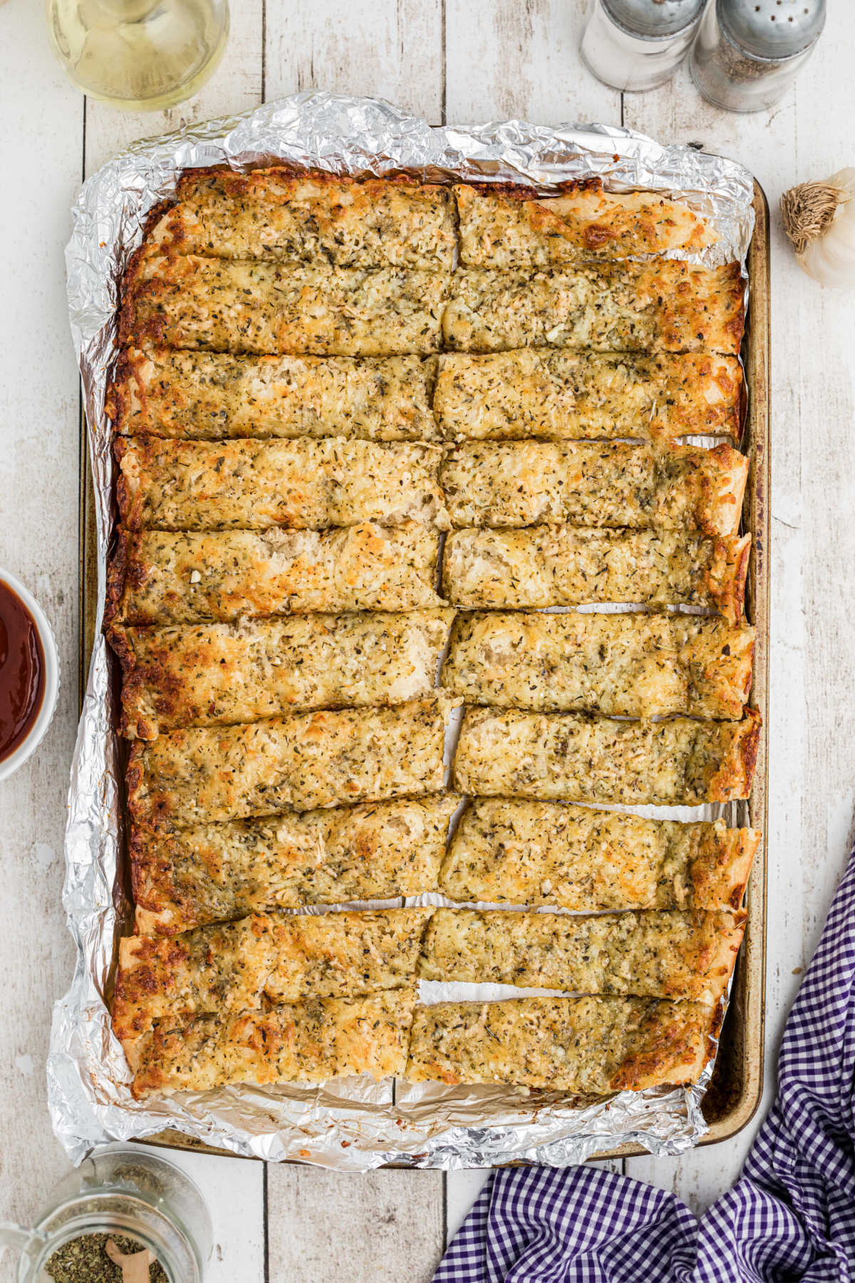 Full overhead shot of a pan full of little caesars italian cheese bread sticks.