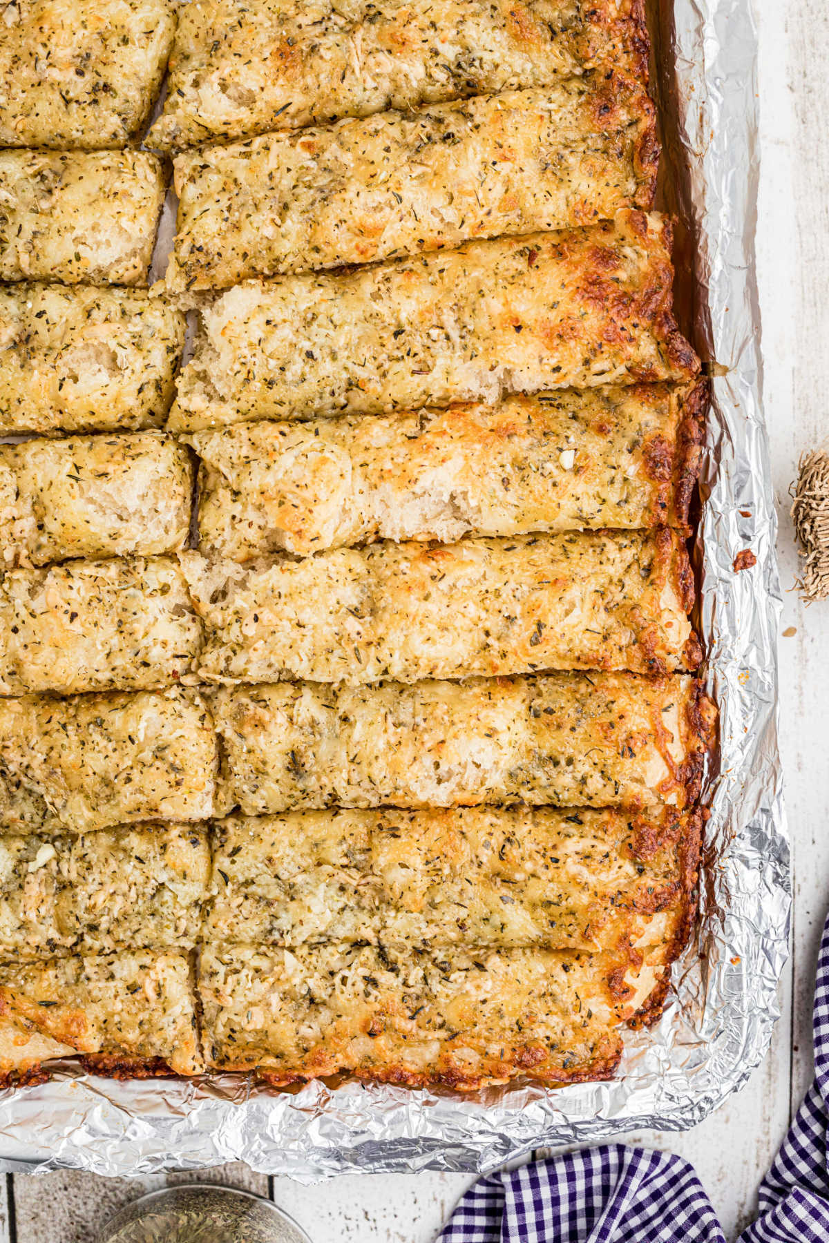 Close up view of the corner of a pan of little caesars italian cheese bread.