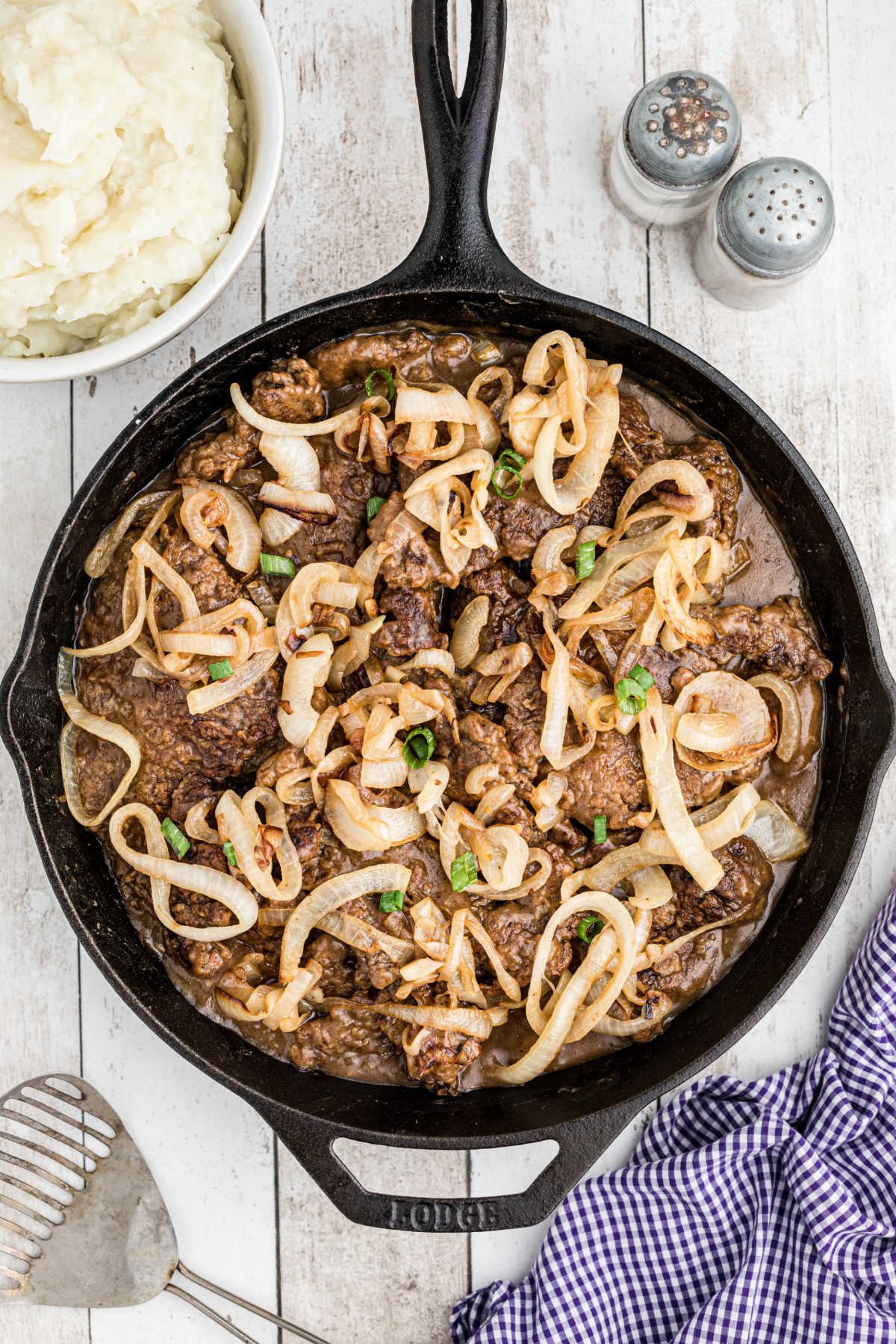 Overhead shot of a cast iron pan with southern liver and onions with gravy.