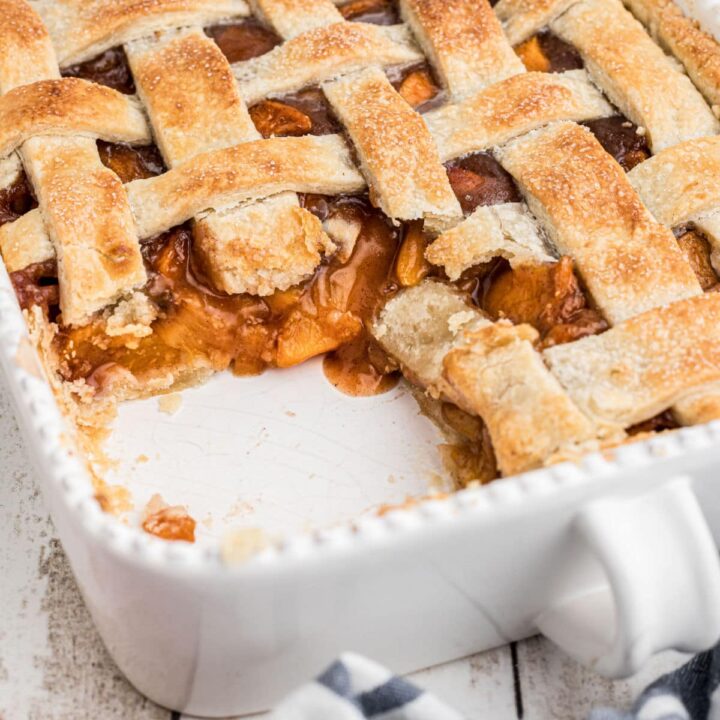 dish with a southern peach cobbler with pie crust, some missing, cropped square.