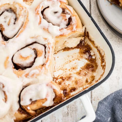 A baking dish with Amish Cinnamon Rolls with one missing. Cropped square.