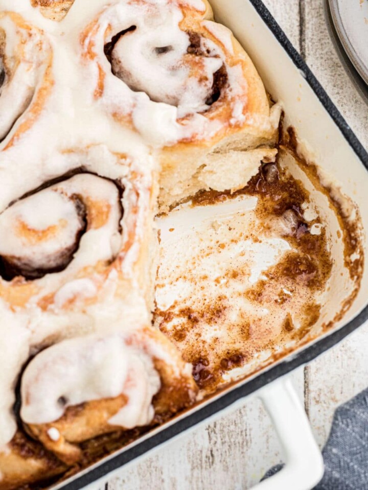 A baking dish with Amish Cinnamon Rolls with one missing. Cropped square.