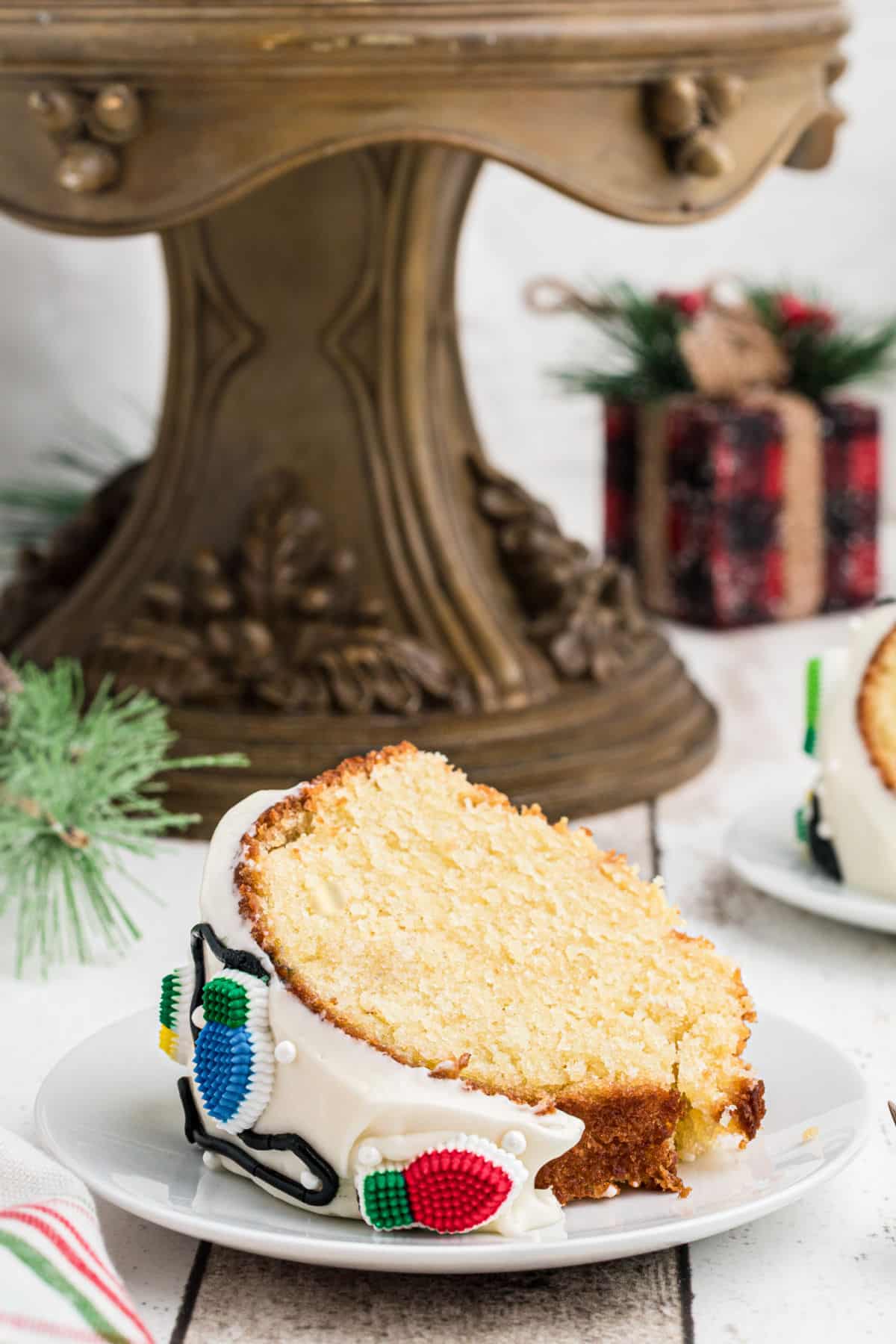 A slice of Christmas Bundt Cake in front of a cake stand.