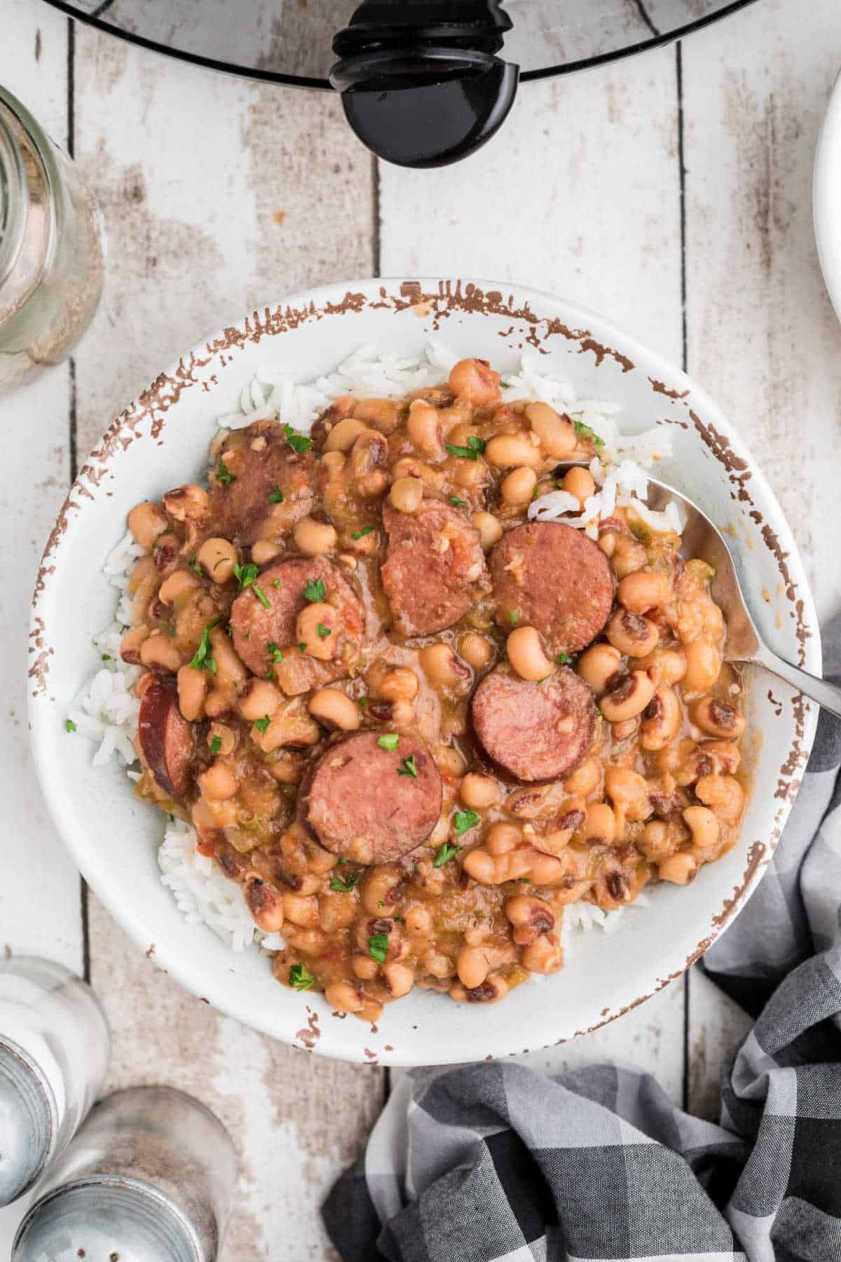 A bowl full of crock pot hoppin john on rice.