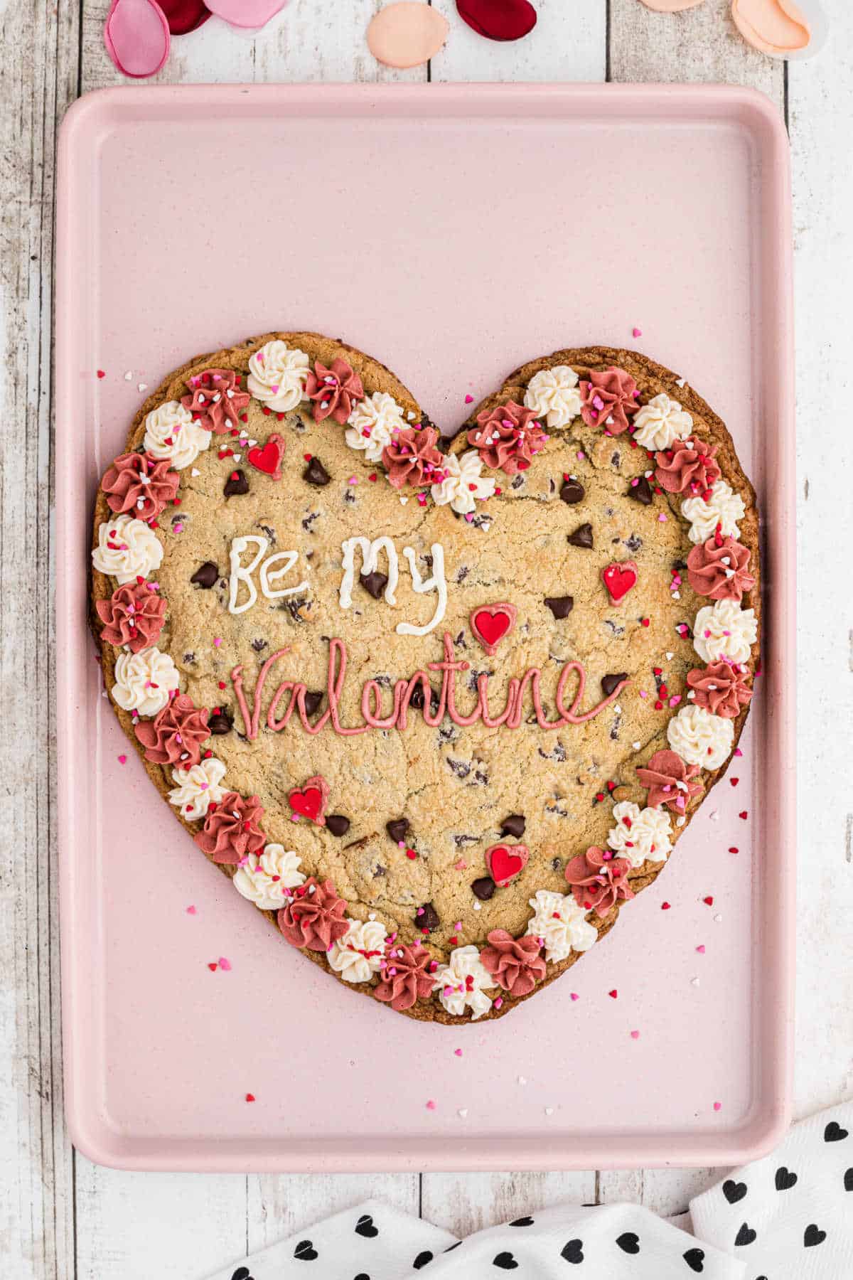 An overhead shot of a giant valentines cookie on a baking sheet.